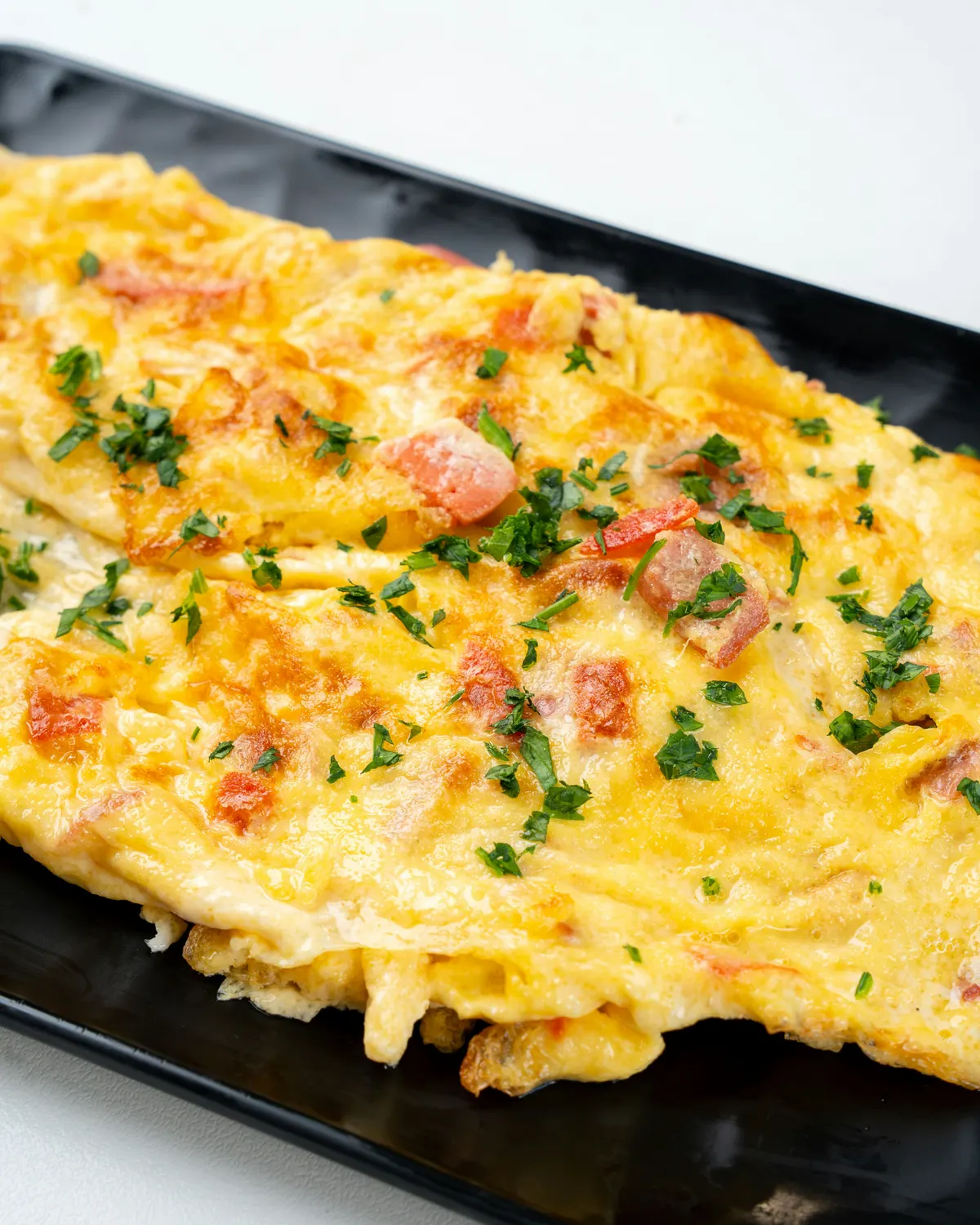 Tortilla de papas cortada en porciones, servida en un plato